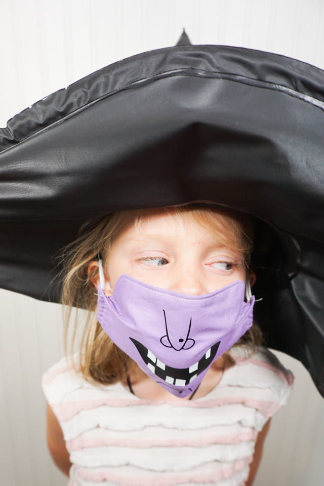 girl wearing witch mask