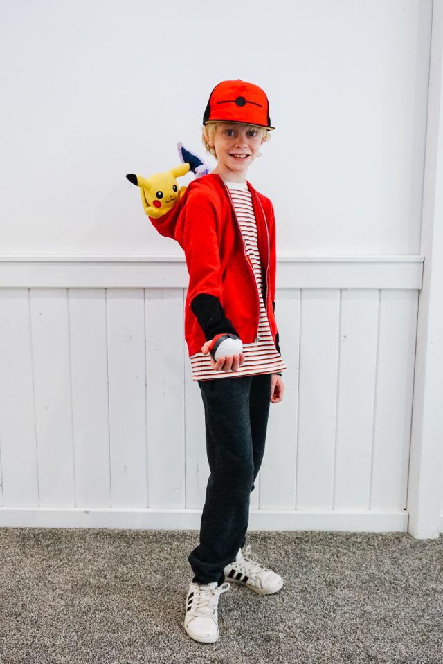 A POKéMON Trainer with a red jacket on a black T-shi