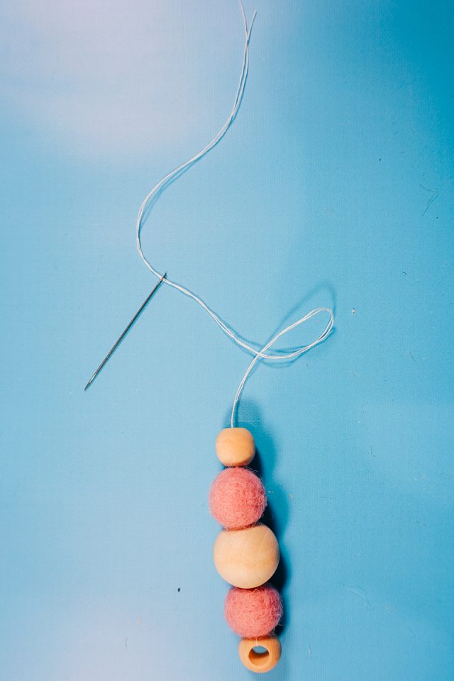 push double string through other beads and felt balls