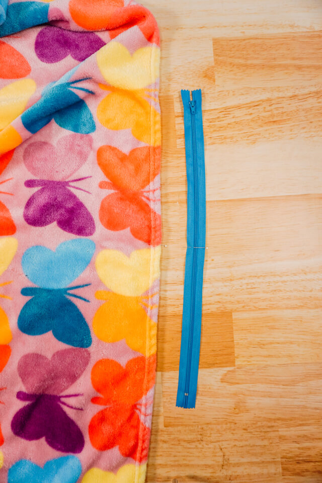 find center of zipper. match center of zipper with center of blanket.