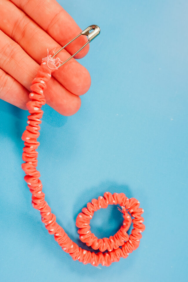 pull the elastic through and pull the other end out of the tube
