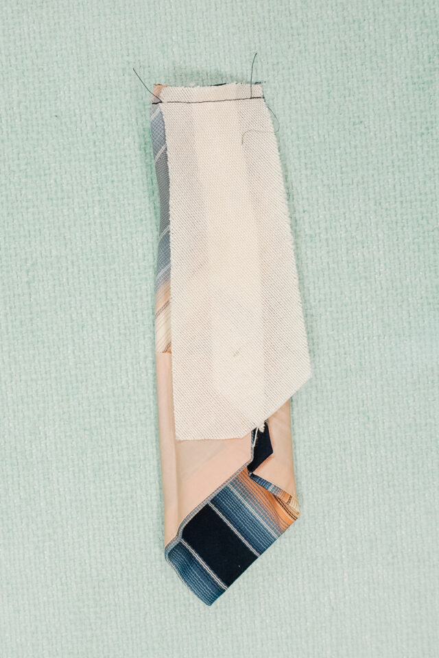 slide lobster clasp into cut end. sew the cut end closed.