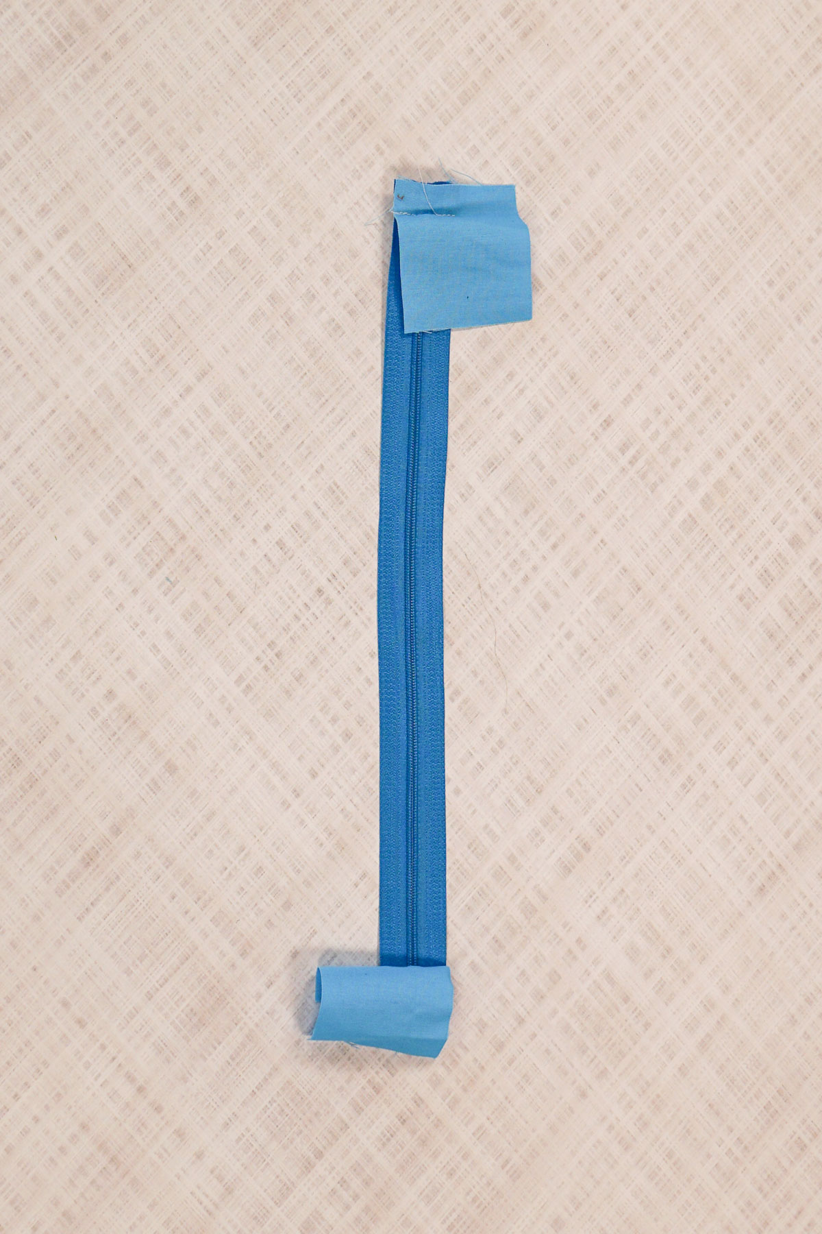 sew short ends of zipper tab onto zipper ends