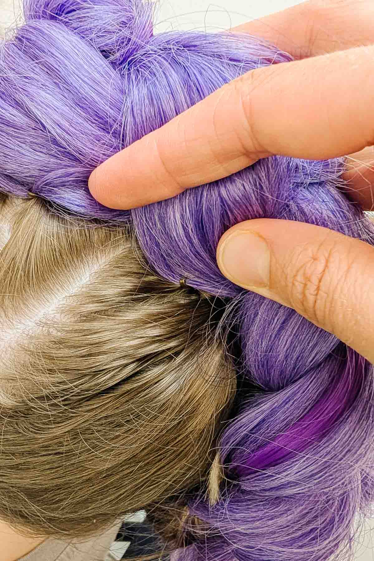 use bobby pins to pull purple braid down around hair braid