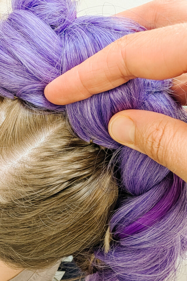 use bobby pins to pull purple braid down around hair braid
